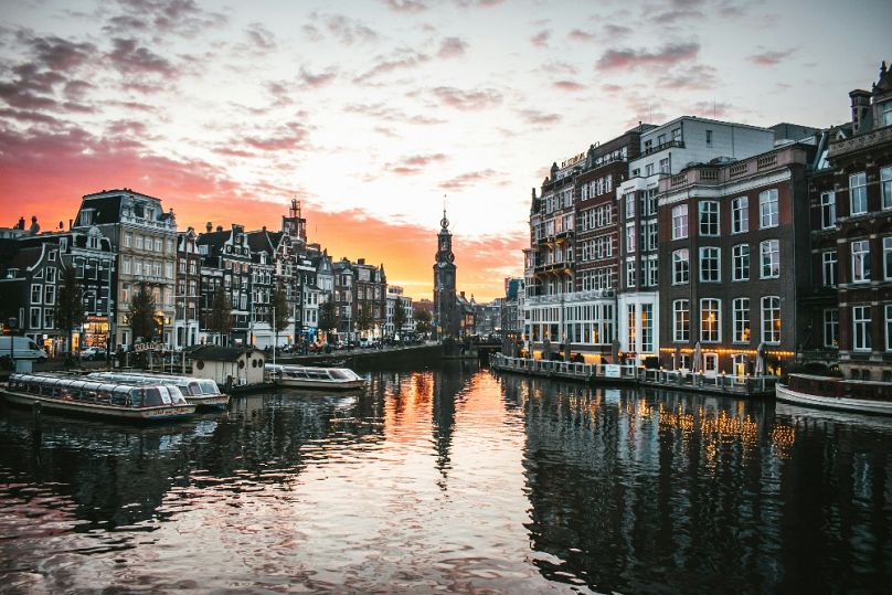 Sunset over Muntplein in Amsterdam, reflected in the city's beautiful canals