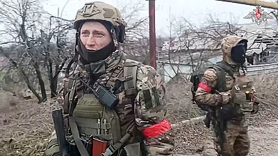  جنديان روسيان يسيران بعد القضاء على خطر الألغام في مدينة أفدييفكا الأوكرانية- 19 شباط 2024.