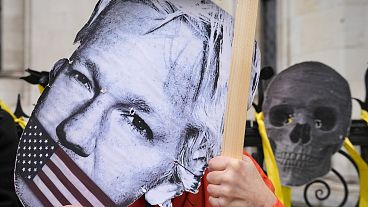 A demonstrator holds a Julian Assange mask outside the Royal Courts of Justice in London, Tuesday, February 20, 2024.