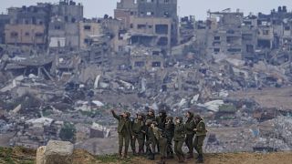 جنديات إسرائيليات يلتقطن صورة خلفيتها غزة المدمرة