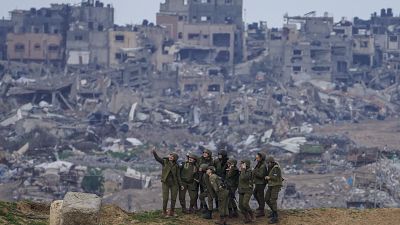 عناصر من الجيش الإسرائيلي يلتقطون صورة سيلفي ومن خلفهم الدمار في غزة 