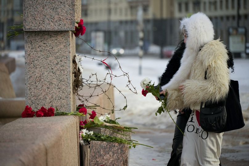 Women lay flowers at the Memorial to Victims of Political Repression to pay respect to Alexei Navalny in St. Petersburg, Russia, Tuesday, Feb. 20, 2024.