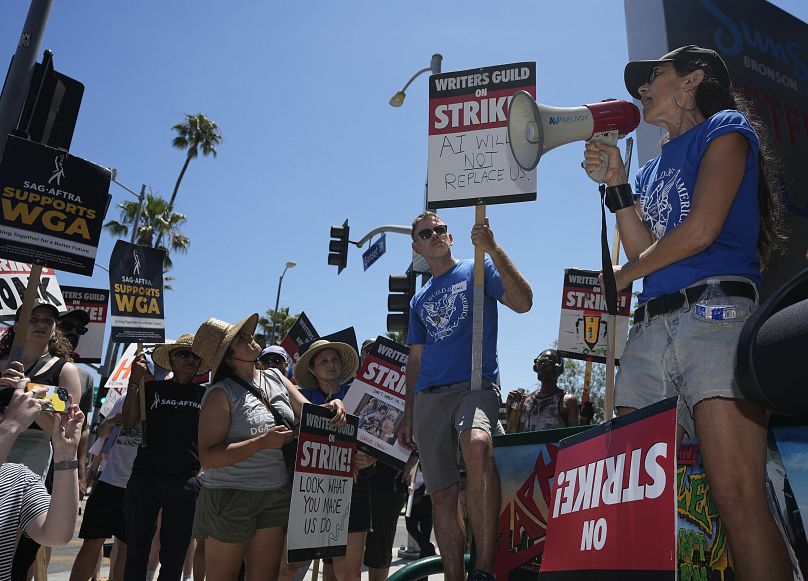 Actor and filmmaker Justine Bateman, right, speaks outside Netflix during a Writers Guild rally.