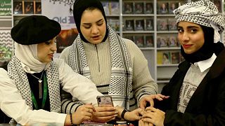 نساء يرتدين الكوفية الفلسطينية خلال المشاركة في المعرض