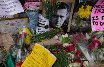 FILE - Flowers and portraits are left opposite the Russian embassy, to commemorate the death of Alexei Navalny in London, Monday, Feb. 19, 2024. 