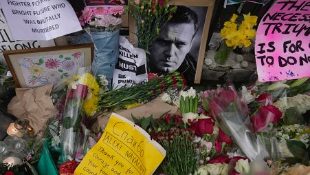 FILE - Flowers and portraits are left opposite the Russian embassy, to commemorate the death of Alexei Navalny in London, Monday, Feb. 19, 2024. 