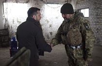 Президент Украины Владимир Зеленский (слева) пожимает руку солдату во время визита в прифронтовой город Купянск Харьковской области, Украина, 19 февраля 2024 года.