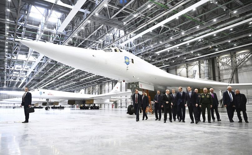 El presidente ruso Vladímir Putin, junto a un grupo de funcionarios, pasa junto a un bombardero estratégico Tu-160M mientras visita la fábrica de Kazán