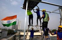 Workers of Solar Square place a panel on the rooftop of a residence in Gurugram on the outskirts of New Delhi.