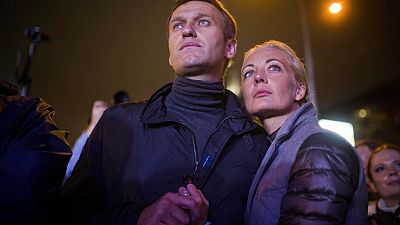 FILE - Russian opposition leader Alexei Navalny, left, and his wife Yulia after a rally in rain-soaked Moscow, Russia, Sept. 6, 2013.