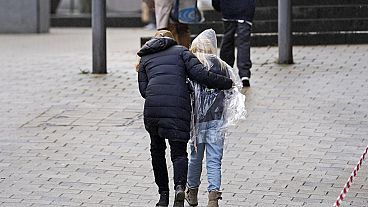 Parents pick up their children after a scene of an attack, at the Wilhelm Doerpfeld School, in Wuppertal, Germany, Thursday, Feb. 22, 2024.