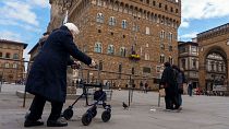 Una donna anziana utilizza un deambulatore per muoversi davanti al Palazzo Vecchio (XIV secolo) a Firenze, giovedì 17 febbraio 2022. 