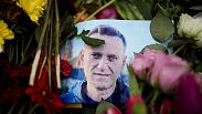 Rain drops cover a portrait of Russian opposition leader Alexei Navalny, placing between flowers in front of the Russian embassy in Berlin