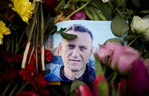 Rain drops cover a portrait of Russian opposition leader Alexei Navalny, placing between flowers in front of the Russian embassy in Berlin