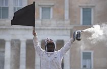 Ein Imker hält während einer Demonstration vor dem griechischen Parlament in der Innenstadt von Athen, Griechenland, am Donnerstag, dem 22. Februar 2024, eine schwarze Flagge.