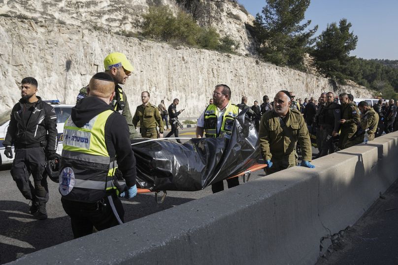 Israeli security forces and members of Zaka rescue service carry a body from the scene of a shooting attack near the West Bank settlement of Maale Adumim, Thursday, Feb. 22,