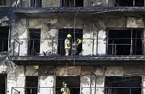 Firefighters remove a charred body inside a burned block building in Valencia, Spain, Friday, Feb. 23, 2024. 
