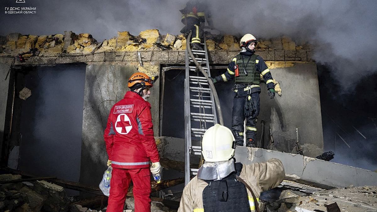   رجال الإطفاء يعملون في موقع مبنى محترق بعد هجوم روسي في أوديسا، أوكرانيا،23 شباط 2024.