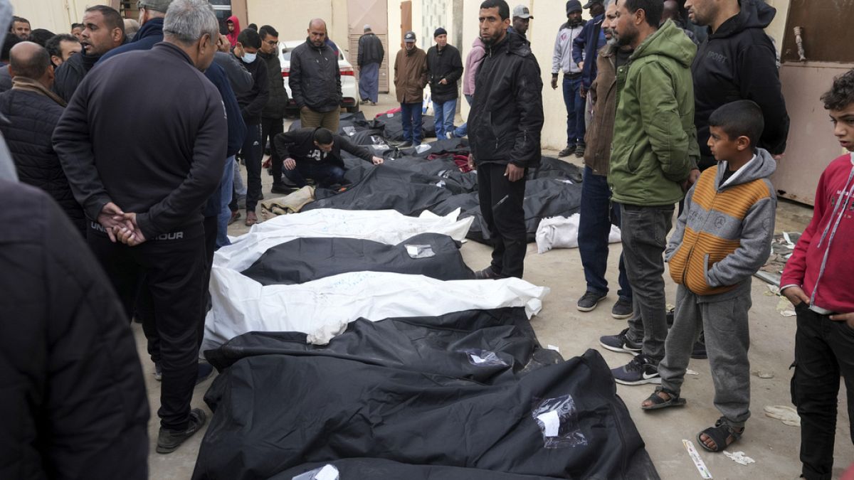Palestinians stand by their dead relatives, who were killed in Israeli airstrikes, at the Al Aqsa Hospital in Deir al Balah, February 23 2024