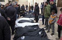 Palestinians stand by their dead relatives, who were killed in Israeli airstrikes, at the Al Aqsa Hospital in Deir al Balah, February 23 2024