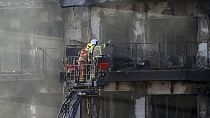 Firefighters work at a burnt out residential building in Valencia, Spain, Friday, Feb. 23, 2024.