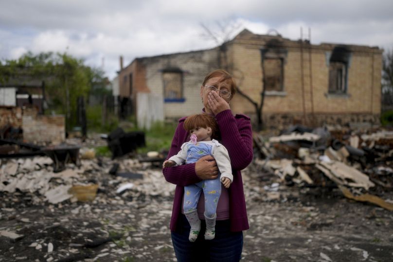 Nila Zelinska holds a doll belonging to her granddaughter she found in her destroyed house in Potashnya, in the outskirts of Kyiv, May 2022