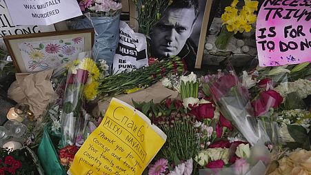 Flowers and portraits are left opposite the Russian embassy, to commemorate the death of Alexei Navalny in London, Monday, Feb. 19, 2024.