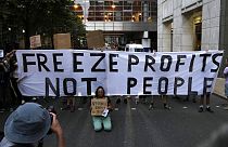 Demonstrators hold up placards as they protest outside the British energy regulator, Ofgem. London, Friday, Aug. 26, 2022. 