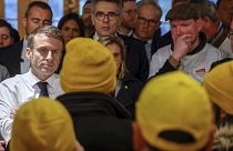 French President Emmanuel Macron, left, speaks with farmers as he visits the International Agriculture Fair on the opening day in Paris, Feb. 24, 2024.