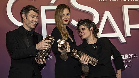 Justine Triet sacrée meilleure réalisatrice (au centre), aux côtés des producteurs du film Anatomie d'une chute, Marie-Ange Luciani et David Thion.