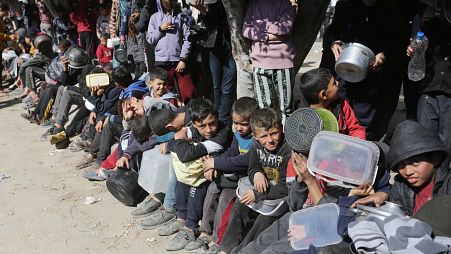 أطفال فلسطينيون يجلسون لساعات طويلة في انتظار الحصول على القليل من الطعام في دير البلح