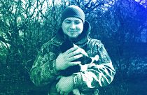 Andrii, 25, a Ukrainian commander of Grad crew, pets a cat, while waiting for orders from command centre at the frontline in Donetsk region, February 2024