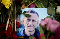 Rain drops cover a portrait of Russian opposition leader Alexei Navalny, placing between flowers in front of the Russian embassy in Berlin, Feb. 21, 2024. 