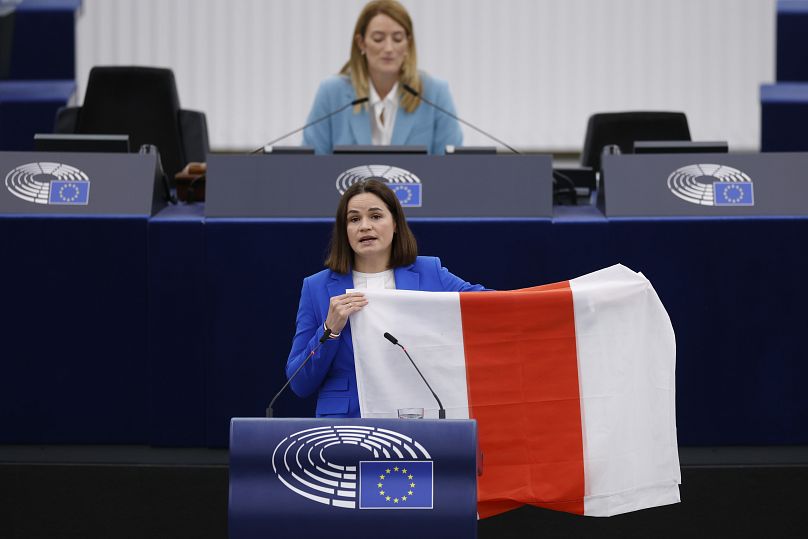سِویئِتلانا سیخانوفس‌کایا، رهبر مخالفان بلاروس با پرچم نمادین اپوزیسیون در حال سخنرانی در پارلمان اتحادیه اروپا به تاریخ ۲۳ سپتامبر ۲۰۲۳