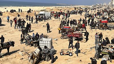 Palestinians wait for humanitarian aid on a beachfront in Gaza City, Gaza Strip, Sunday, Feb. 25, 2024