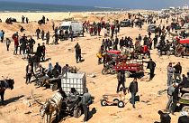 فلسطینیان در انتظار کمک‌های بشردوستانه در ساحل شهر غزه، نوار غزه، یکشنبه، ۲۵ فوریه ۲۰۲۴