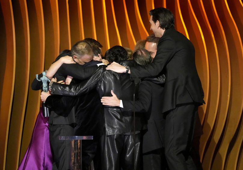 The cast of 'Succession' in a big bear hug onstage for their final appearance together, after winning outstanding performance by an ensemble in a drama series.
