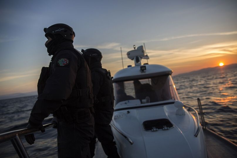 Members of the Frontex patrol as the sun rises near the northeastern Greek island of Lesbos, December 2015