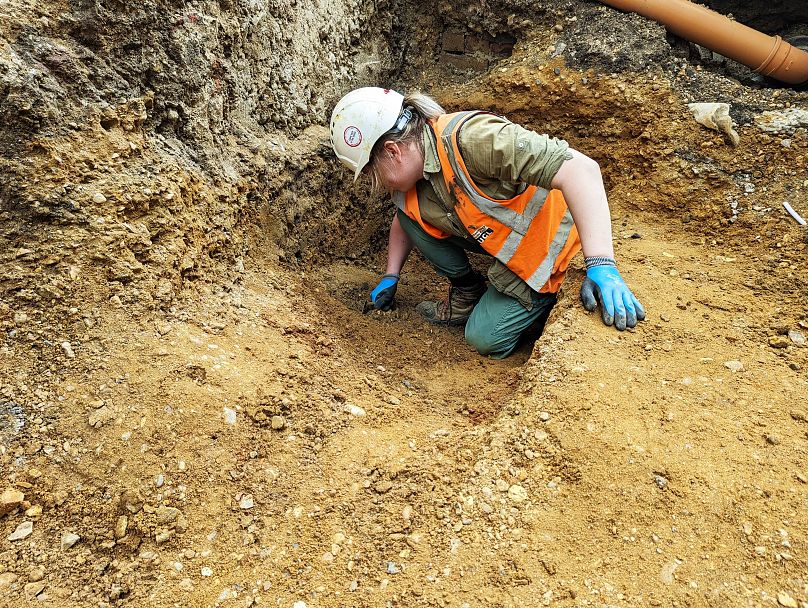 Ein Archäologe gräbt einen sächsischen Graben im Süden des Grabungsbereichs aus.