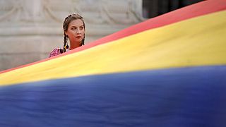 Eine Frau hält eine rumänische Flagge am den Tag der Nationalhymne in Bukarest, den 29. Juli 2019.