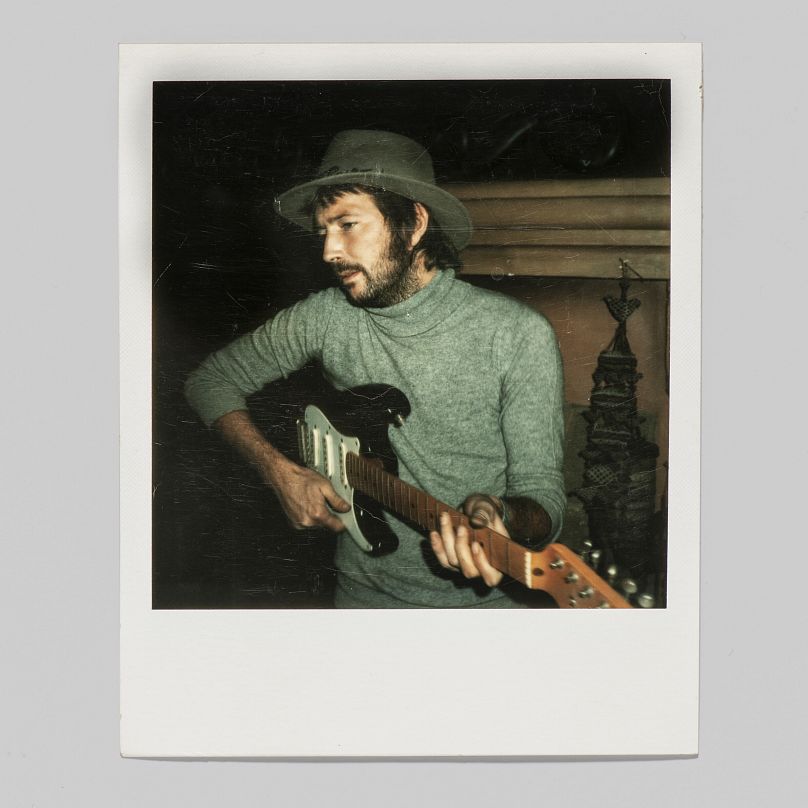 A unique colour Polaroid photograph Pattie Boyd took of Eric Clapton with his favourite Fender Stratocaster guitar, nicknamed 'Blackie', circa 1977.