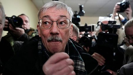 Oleg Orlov stands surrounded by journalists prior to a court session for a new trial on charges of repeated discrediting Russian military, in Moscow, Russia, on February 27.