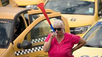 A taxi driver blows into a vuvuzela horn during a protest outside the parliament building in Bucharest, Romania, Tuesday, June 18, 2019. 