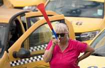 A taxi driver blows into a vuvuzela horn during a protest outside the parliament building in Bucharest, Romania, Tuesday, June 18, 2019. 