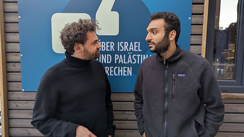 Shai Hoffmann (left) talking with Ahmad Dakhnous (right) outside Tiny Space at Potsdamer Platz, Berlin