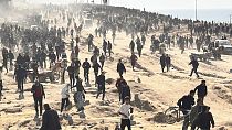 Palestinesi aspettano l'arrivo degli aiuti umanitari su una spiaggia di Gaza City, 25 febbraio 2024