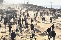 Palestinos esperan ayuda humanitaria en una playa de la ciudad de Gaza, Franja de Gaza
