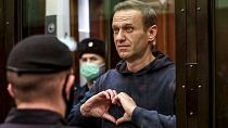 Russian opposition leader Alexei Navalny shows a heart symbol while standing in a defendants’ cage during a hearing in the Moscow City Court in February 2021.