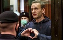 Russian opposition leader Alexei Navalny shows a heart symbol while standing in a defendants’ cage during a hearing in the Moscow City Court in February 2021.