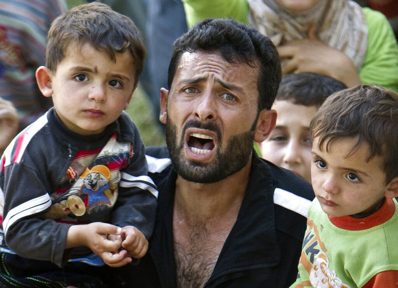 A Syrian refugee man surrounded by children shouts during a spontaneous protest against Syrian President Bashar Assad, in a camp in Yayladagi, June 2011